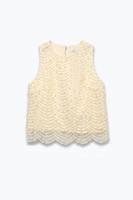 A sleeveless cream-colored knit top with a textured pattern and scalloped lace trim, shown against a plain white background.